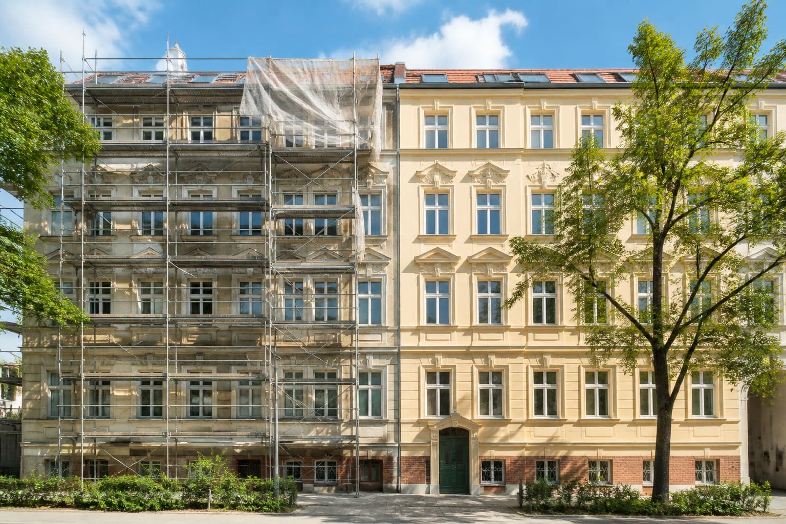 Altbaufassade mit Gerüst, die rechte Hälfte ist frisch gestrichen